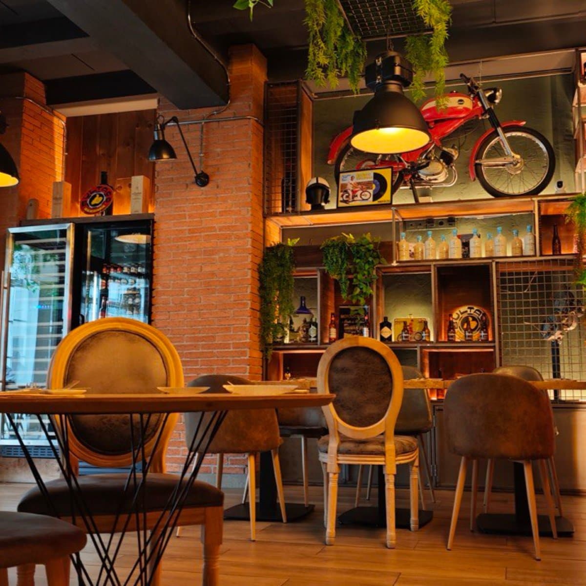 Sala de La Fábrica con la moto roja y el neón